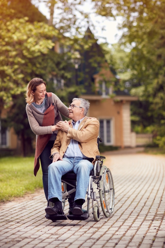 an elderly man in a wheelchair and a woman